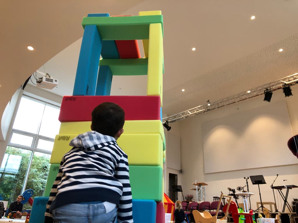 Ein Kind hat einen riesigen Turm aus Schaumstoffbausteinen gebaut